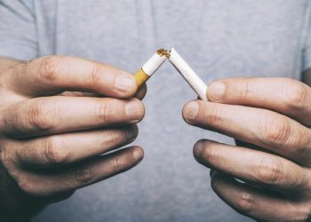 manos rompiendo un cigarrillo